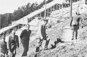 Official opening of the Greater Dividing Range project. " 'Destined to make the Snowy Mountains Scheme look like a puddle". Foreground. minister for Immigration Mr peter Dutton in suit looks thoughtfully at cameraman. Leading, (in uniform) the Minister for the Arts, Mr George Brandis in splendidly designed 'Cultural Leader' uniform. Uniforms generously supplied for the event from the Rt Hon Christopher Pyne's personal collection. Official Photograph.